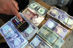 Iraqi, Iranian and American currency being changed on a street stall. Soon the head of Saddam Hussein on Iraqi banknotes will be a thing of the past. The old banknotes are being replaced by new ones.