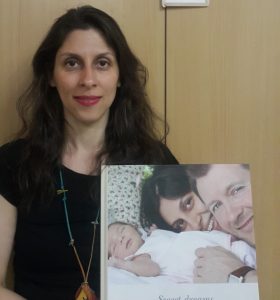 Nazanin Zaghari-Ratcliffe holds a picture of her with her husband and daughter
