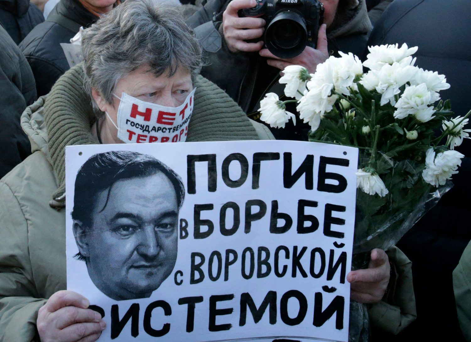 A woman holds a placard with a portrait of Sergei Magnitsky during an unauthorised rally in central Moscow.