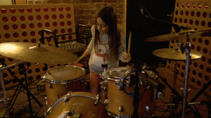 Gabriella Ratcliffe playing drums with The Christians